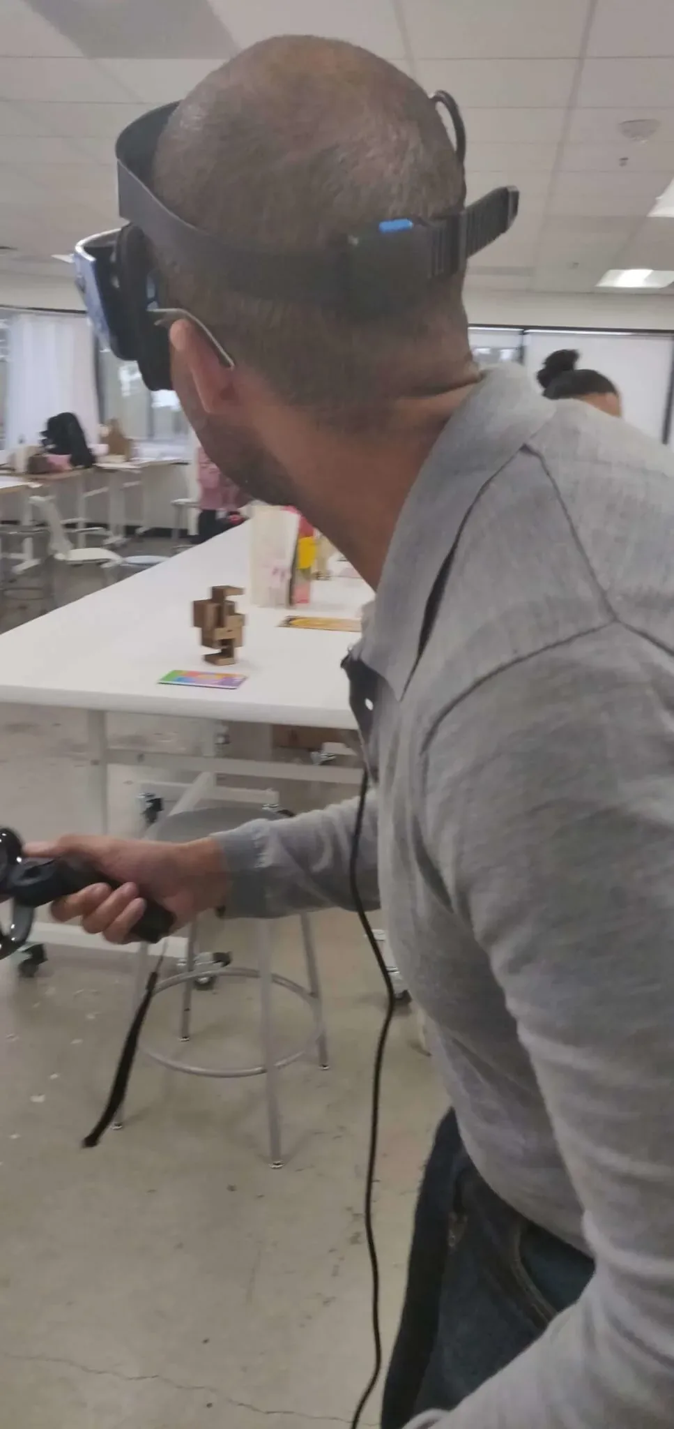 Man slightly crouching under the virtual sculpture wearing a VR headset