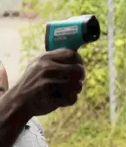 Cropped photo of a hand holding a thermometer gun, classified by an AI model