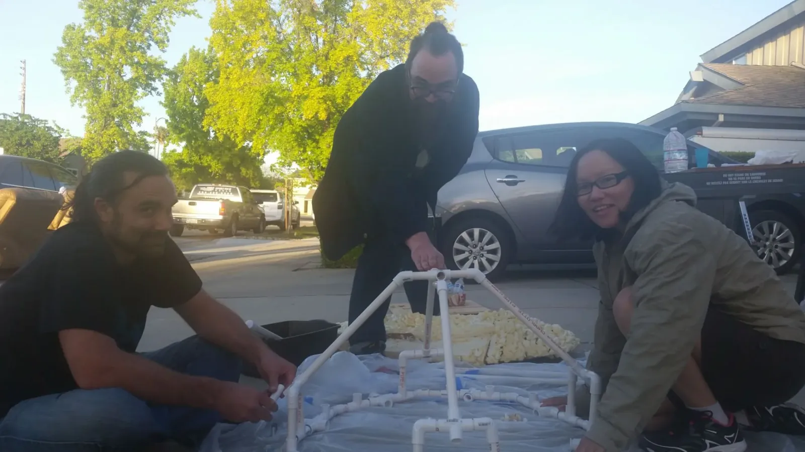 Three people working on the inner cage of the sculpture bulb